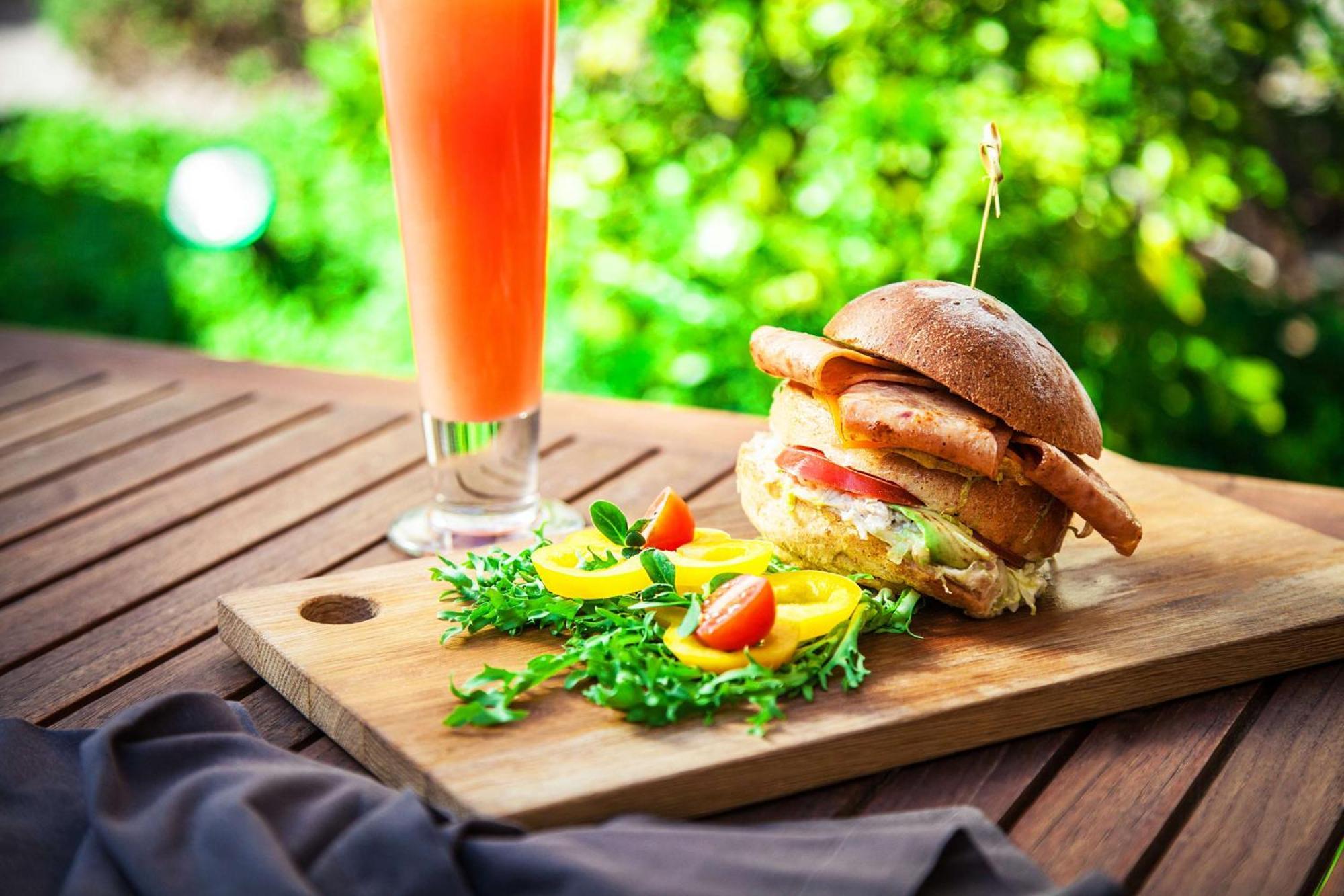Radisson Blu Hotel, Dubai Deira Creek Exterior photo A chicken burger with a glass of orange juice